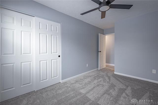 unfurnished bedroom featuring baseboards, ceiling fan, carpet, and a closet