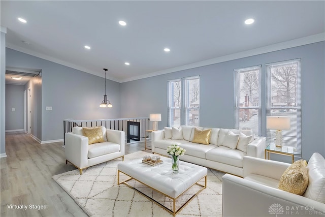 living room with recessed lighting, ornamental molding, light wood finished floors, and baseboards