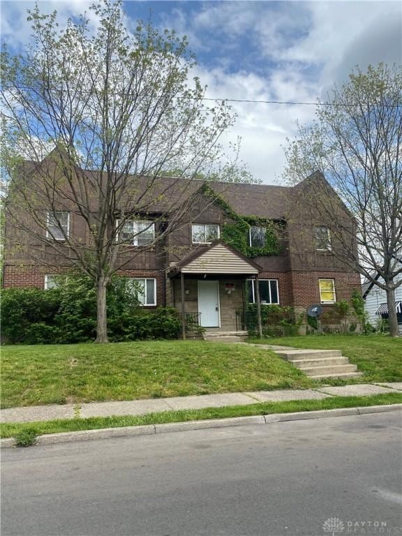 view of front of house featuring brick siding and a front yard