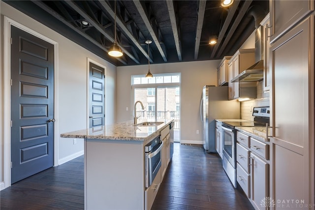 kitchen featuring sink, light stone counters, a center island with sink, pendant lighting, and stainless steel appliances