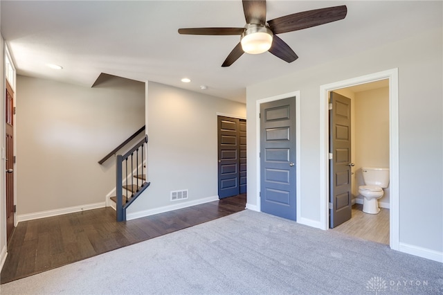 carpeted bedroom featuring ensuite bathroom, ceiling fan, and a closet