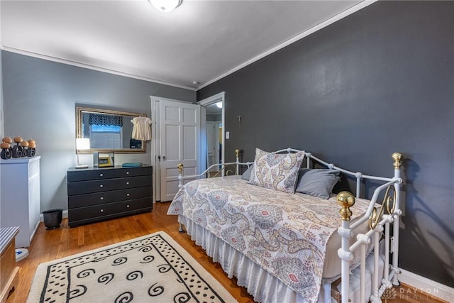 bedroom with ornamental molding and hardwood / wood-style floors