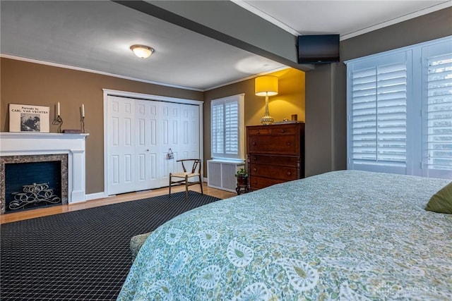 bedroom featuring hardwood / wood-style flooring, a fireplace, and ornamental molding