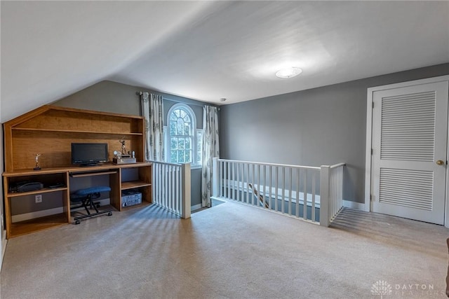 unfurnished office with vaulted ceiling and light carpet