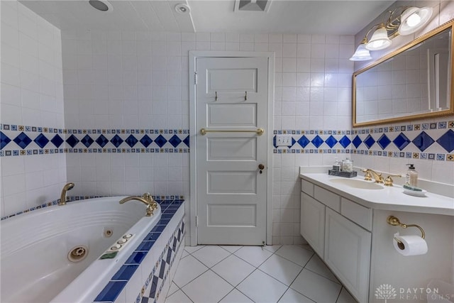 bathroom featuring tile walls, vanity, tile patterned flooring, and a relaxing tiled tub