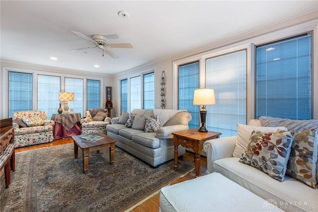 living room featuring hardwood / wood-style floors, ornamental molding, and ceiling fan