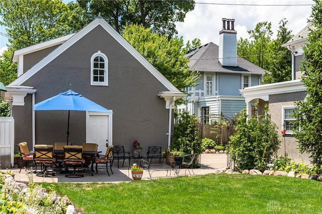 rear view of property featuring a patio and a yard