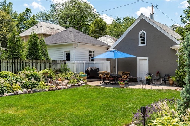 rear view of house featuring a lawn and a patio area