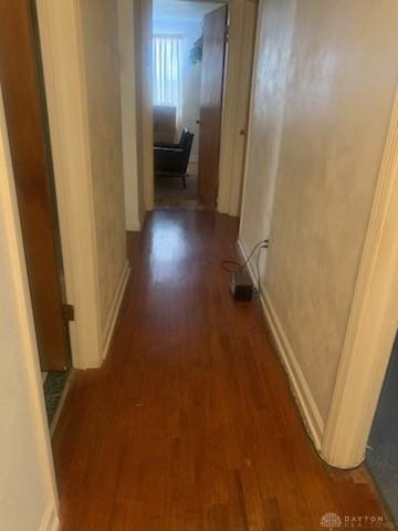 corridor with dark hardwood / wood-style flooring