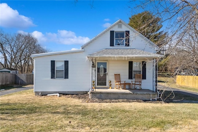 bungalow-style house with a front lawn, fence, and a porch