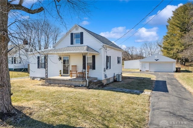 view of front of property featuring a garage, a porch, a front lawn, and an outdoor structure