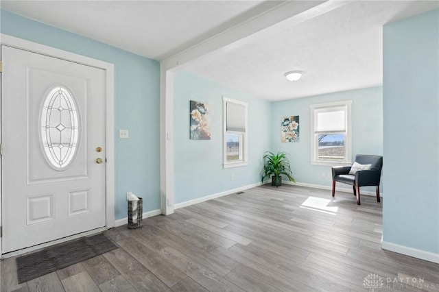 foyer featuring baseboards and wood finished floors