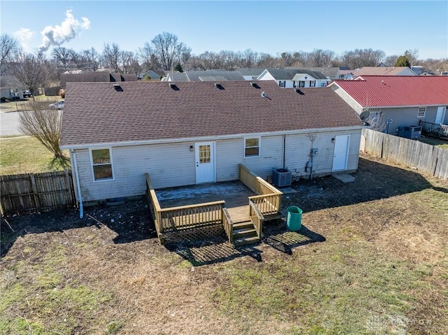 rear view of property featuring a wooden deck and a lawn