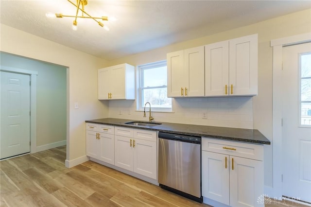 kitchen with tasteful backsplash, sink, white cabinets, stainless steel dishwasher, and light hardwood / wood-style flooring