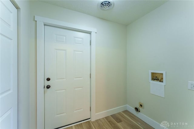 clothes washing area with electric dryer hookup, washer hookup, and light hardwood / wood-style flooring