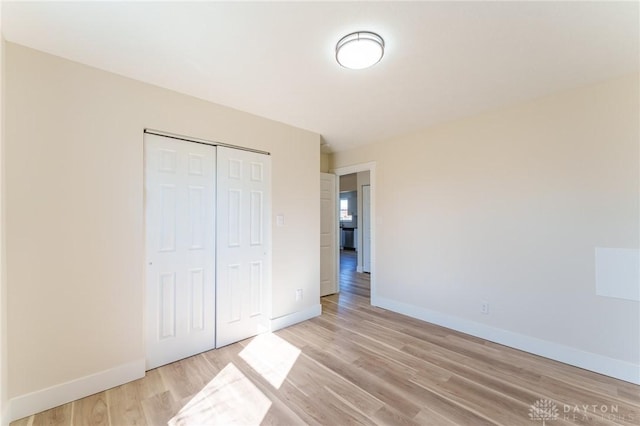 unfurnished bedroom featuring a closet and light wood-type flooring