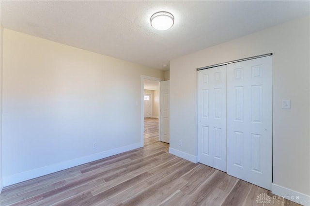 unfurnished bedroom with light hardwood / wood-style floors and a closet