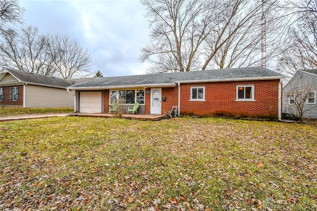 single story home featuring a garage, driveway, a front yard, and brick siding