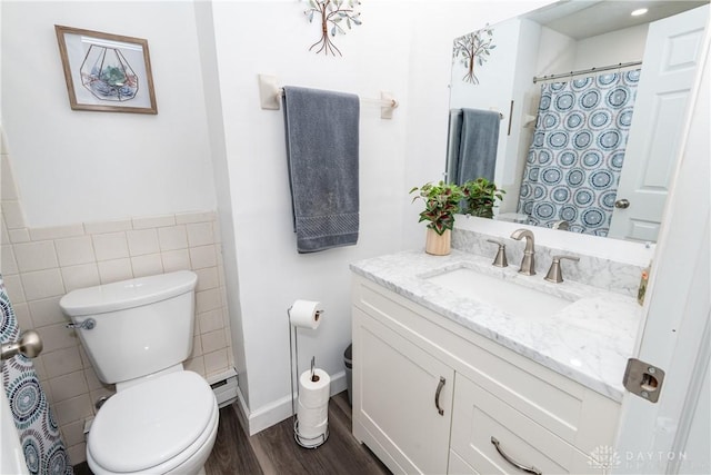 bathroom featuring wood-type flooring, tile walls, vanity, and toilet