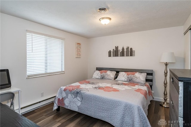 bedroom featuring a baseboard heating unit, dark wood-type flooring, and a textured ceiling