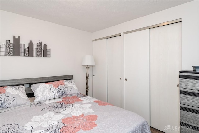 bedroom with two closets and a textured ceiling