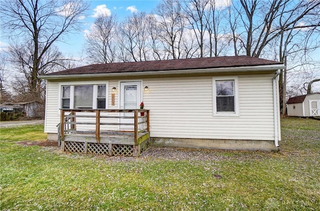 view of front of home with an outbuilding, a shed, a front yard, and a wooden deck