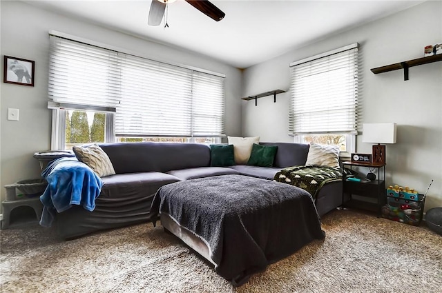 carpeted living area featuring a ceiling fan and plenty of natural light