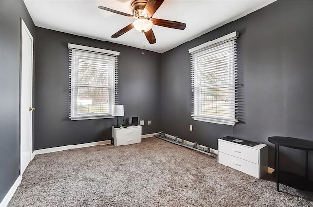 miscellaneous room featuring baseboards, carpet floors, ceiling fan, and a healthy amount of sunlight