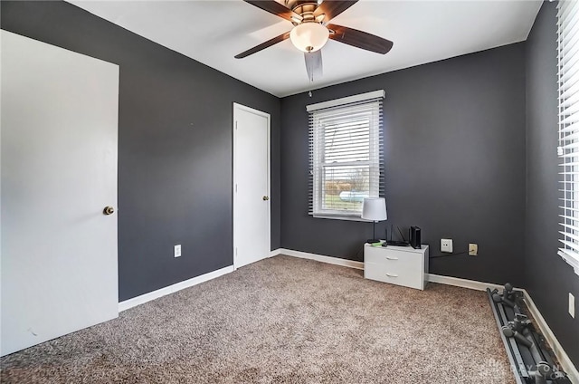 spare room with carpet floors, baseboards, and a ceiling fan