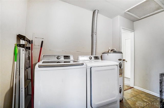 laundry area with water heater, attic access, washer and dryer, laundry area, and baseboards