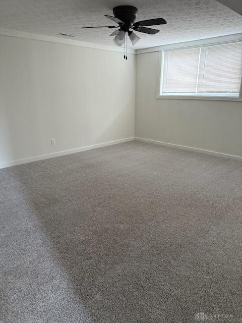 carpeted empty room with ornamental molding, ceiling fan, and a textured ceiling