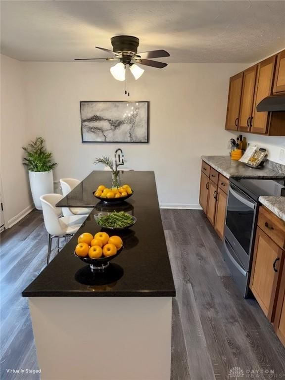 kitchen with stainless steel electric range, dark wood-type flooring, and ceiling fan