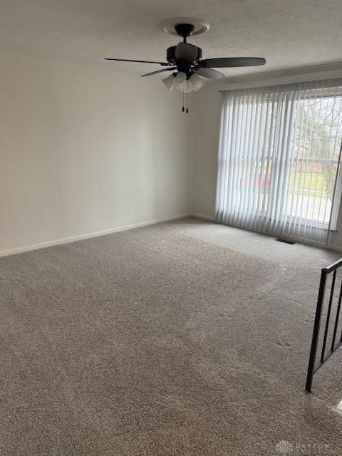 spare room featuring ceiling fan, carpet flooring, and a textured ceiling