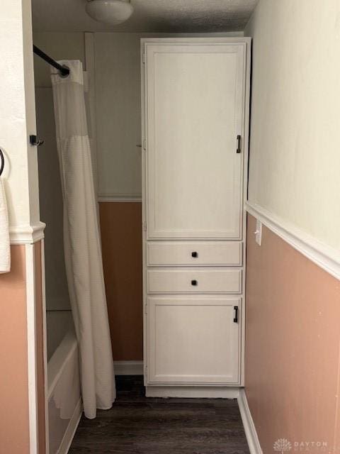 interior space with shower / tub combo with curtain and wood-type flooring