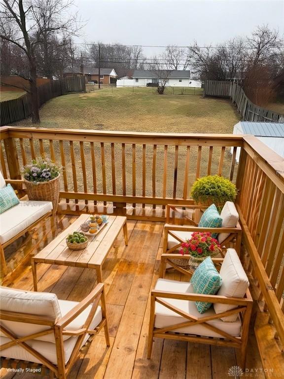 wooden terrace featuring an outdoor hangout area and a lawn