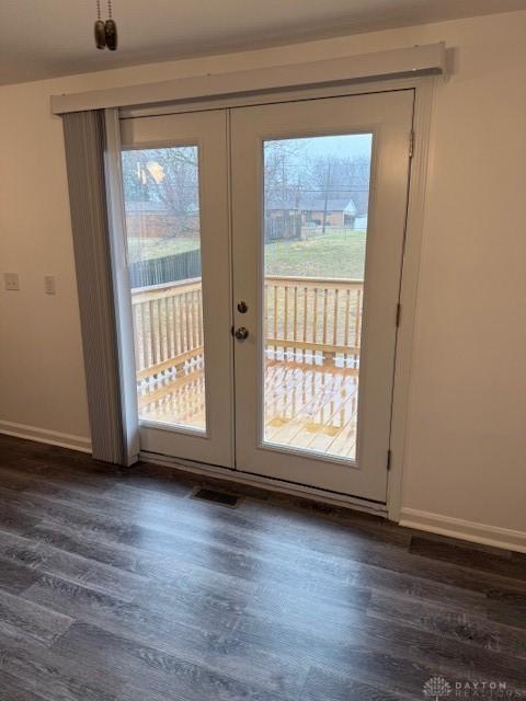 doorway with dark hardwood / wood-style floors, a wealth of natural light, and french doors