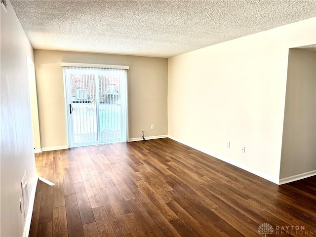 spare room with dark hardwood / wood-style flooring and a textured ceiling