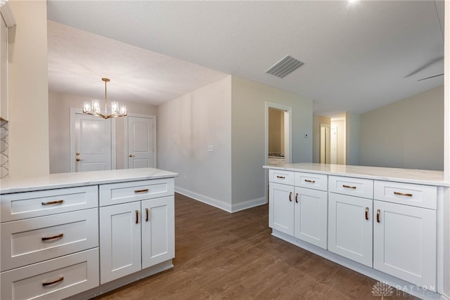 2220 Tandem Dr, Xenia, OH 45385 - kitchen with white cabinetry, dark hardwood / wood-style floors, an inviting chandelier, and decorative light fixtures