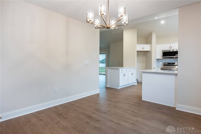 2220 Tandem Dr, Xenia, OH 45385 - interior space featuring tasteful backsplash, white cabinets, dark hardwood / wood-style flooring, hanging light fixtures, and stainless steel appliances