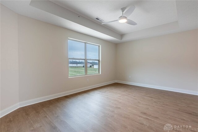 2220 Tandem Dr, Xenia, OH 45385 - unfurnished room with ceiling fan, wood-type flooring, and a tray ceiling