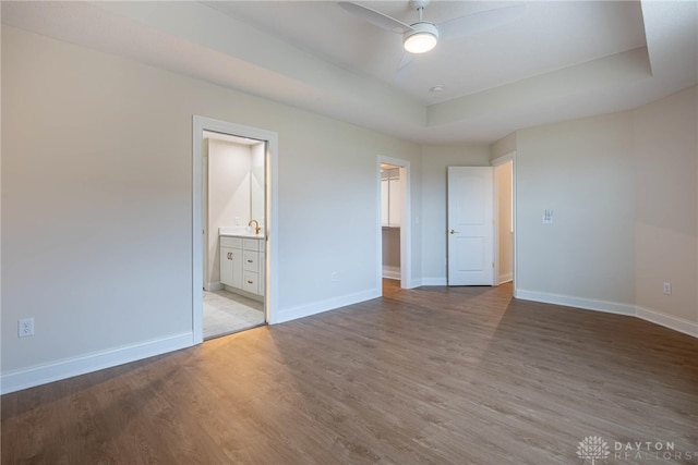 2220 Tandem Dr, Xenia, OH 45385 - unfurnished bedroom with sink, a tray ceiling, a spacious closet, and light wood-type flooring