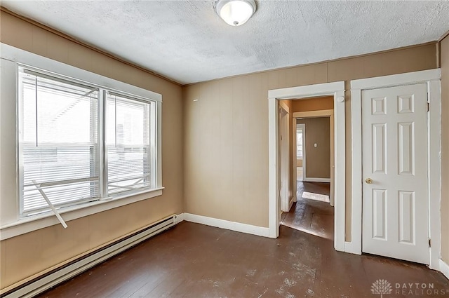 spare room with a textured ceiling and baseboard heating