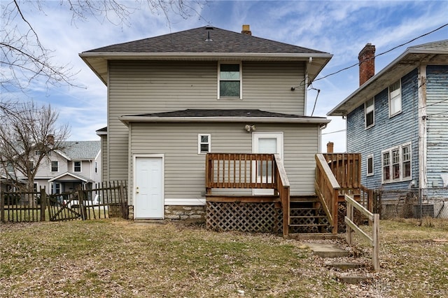 back of property with a wooden deck and a yard