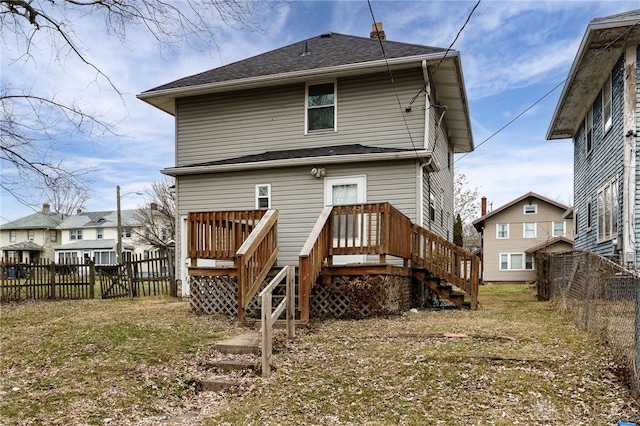 rear view of house featuring a yard and a deck