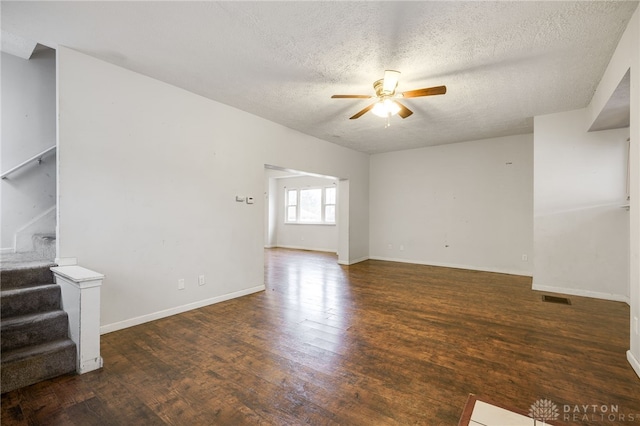 unfurnished living room featuring dark hardwood / wood-style flooring, ceiling fan, and a textured ceiling