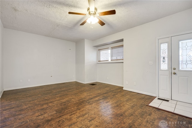 foyer entrance featuring ceiling fan, dark hardwood / wood-style flooring, and a textured ceiling