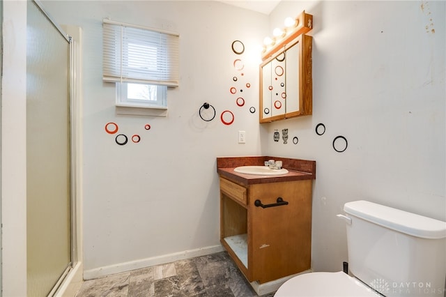 bathroom featuring vanity, a shower with door, and toilet