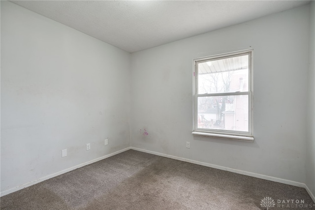 empty room with carpet floors and a textured ceiling