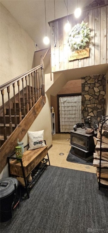 carpeted living room featuring a high ceiling and a wood stove