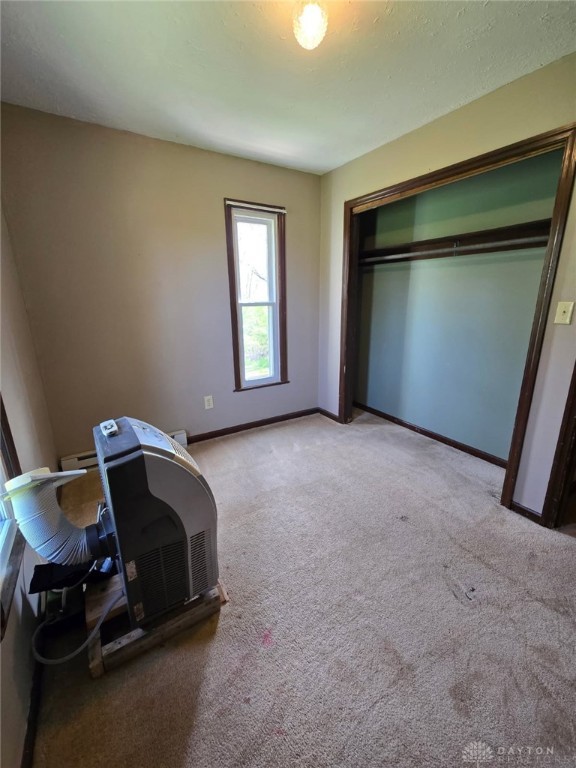 unfurnished bedroom featuring a closet, carpet floors, and baseboards